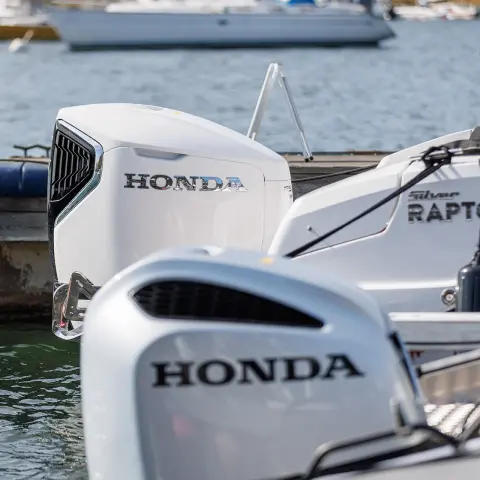 Närbild av Honda BF-motorer på båtar i vattnet.
