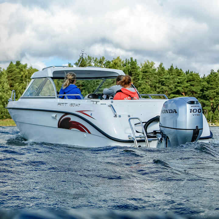 Familj i en båt på en sjö med Honda BF80-100-motor.